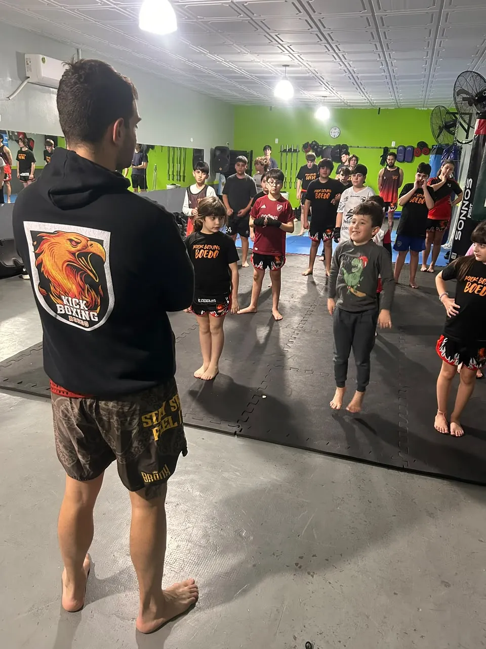 Clase de Kick Boxing para chicos en Boedo: el profesor explica a un grupo de niños y niñas